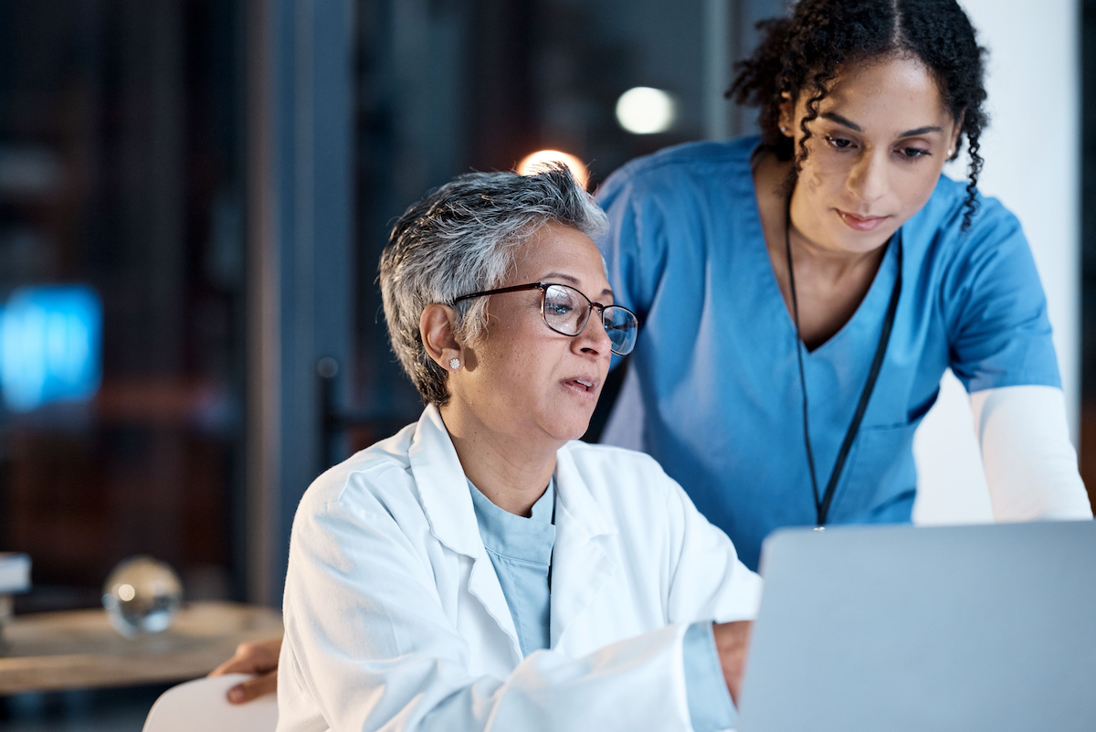 Doctors, nurse or laptop in night teamwork, medical research or surgery planning in wellness hospital. Talking, thinking or healthcare women on technology for collaboration help or life insurance app.